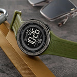 Green digital watch on a textured surface with a blurred background