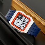 Digital watch with blue strap on a dark surface